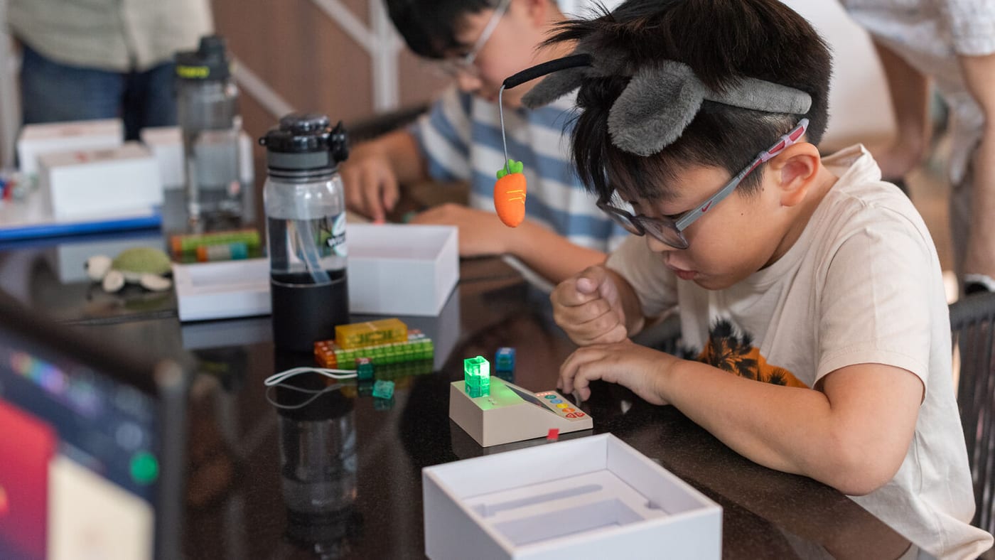 A boy in a classroom building a brick program on the CodePad